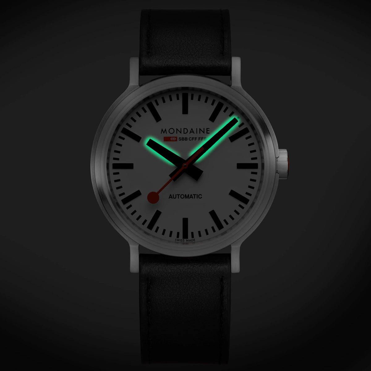 Mondaine The Original MST.4161B.LBV automatic timepiece in dark setting showing green Super-LumiNova glowing hands