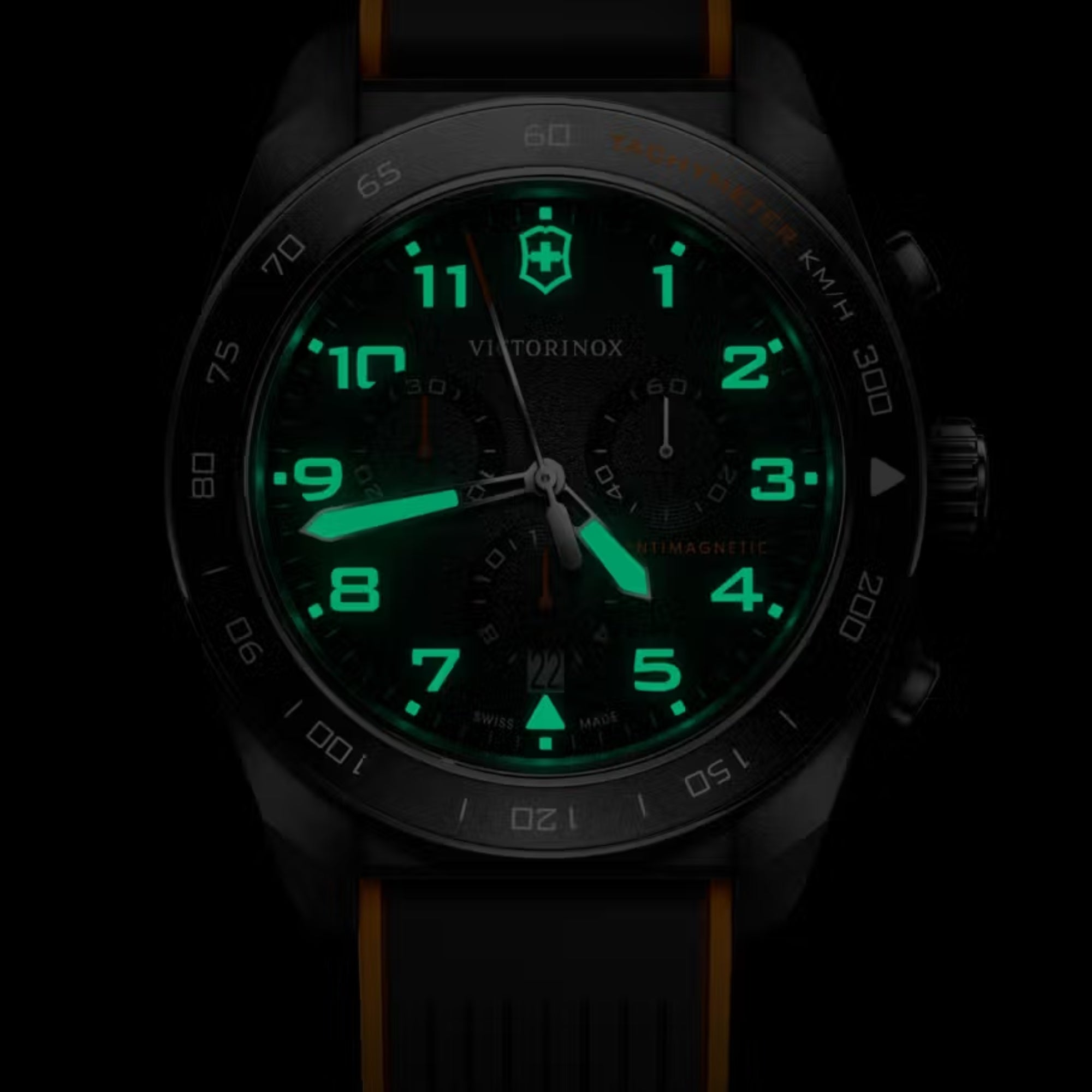 Victorinox Swiss Army 242050 chronograph watch with glowing luminous hands and markers on black dial in dark setting
