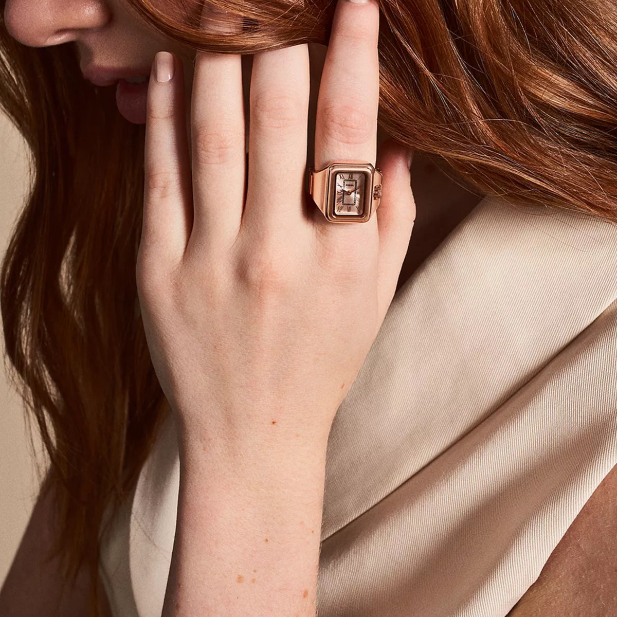 Rose gold-tone steel wrist watch on wrist, square dial with Roman numerals and crown