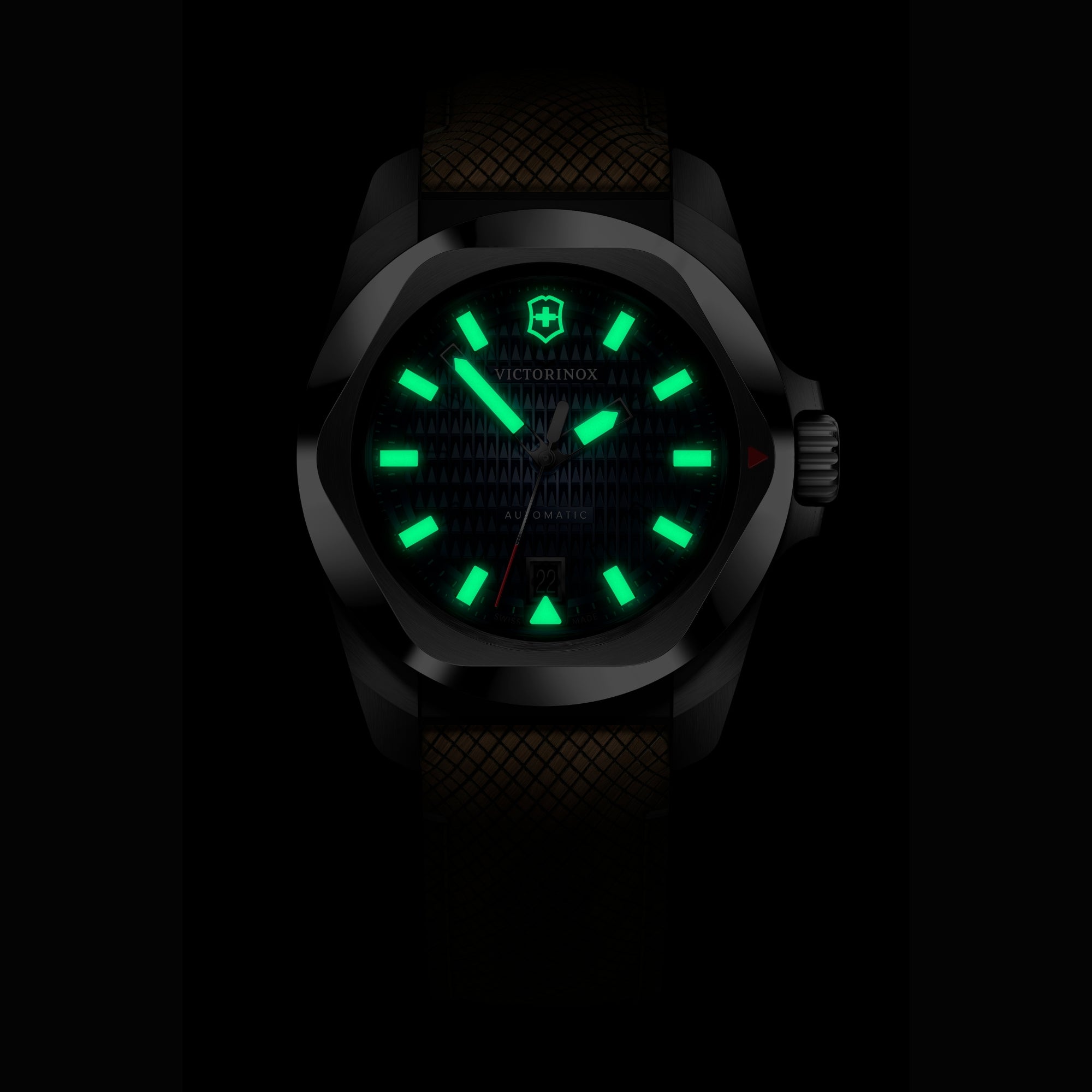 A dark close-up shot of a Victorinox watch featuring green glowing lume