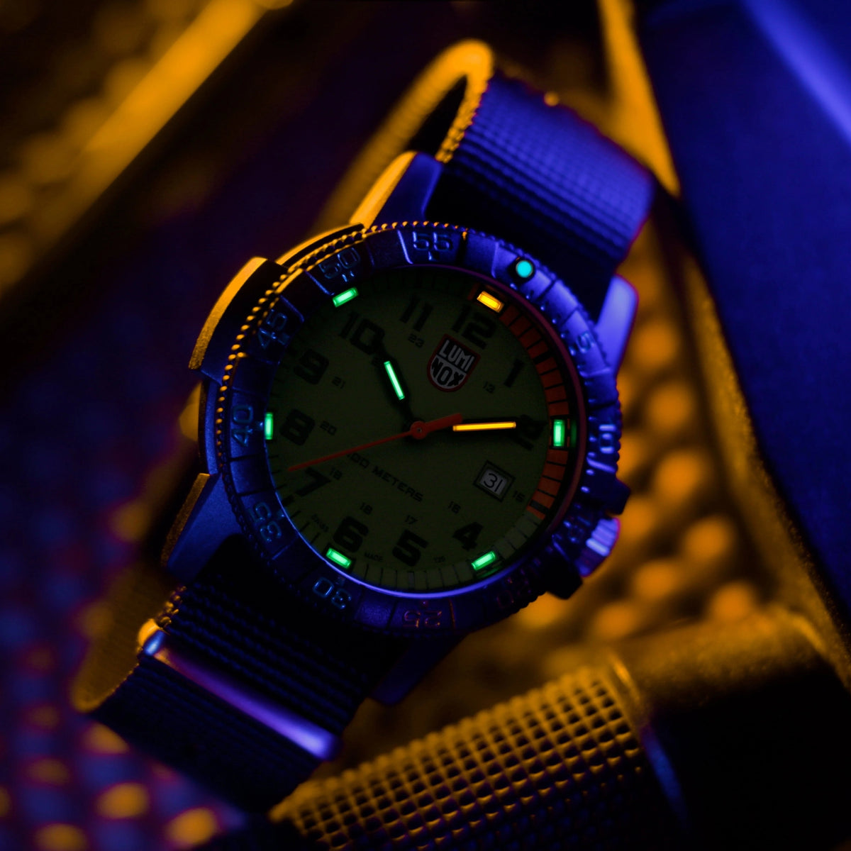 Quartz watch with green dial, orange seconds hand, and blue-lit fabric strap