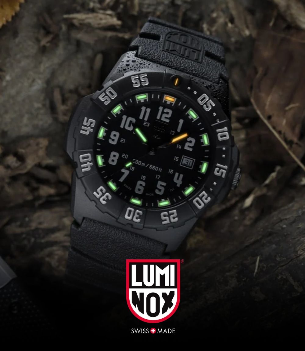 A black Luminox outdoor watch with a textured strap and glowing green, orange, and white details, shown resting on a dark wood surface with a Luminox logo overlay at the bottom
