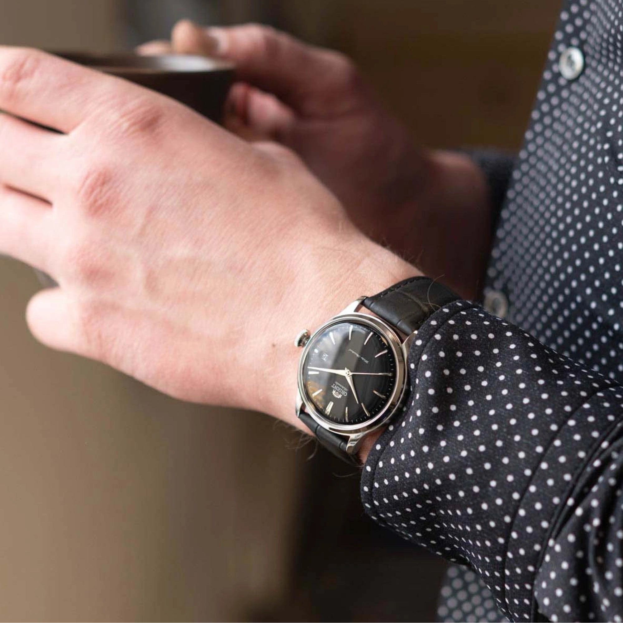 Orient RA-AC0M02B10B black dial watch worn on a wrist
