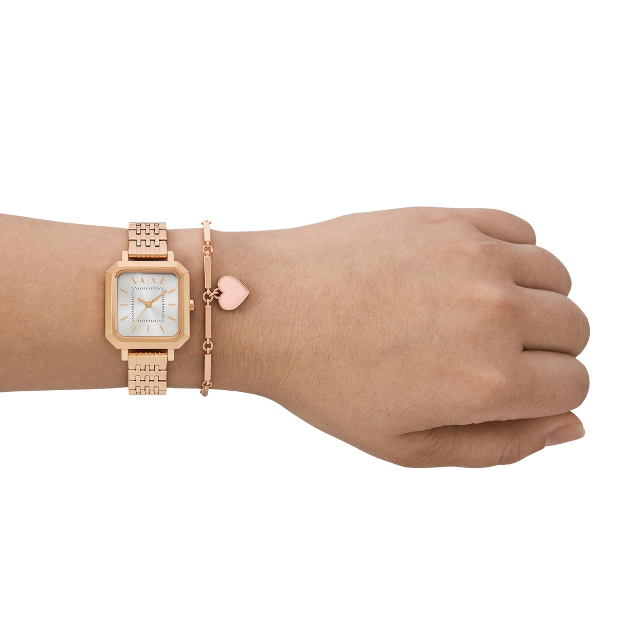 Rose-gold ladies watch and bracelet on wrist with pink heart charm