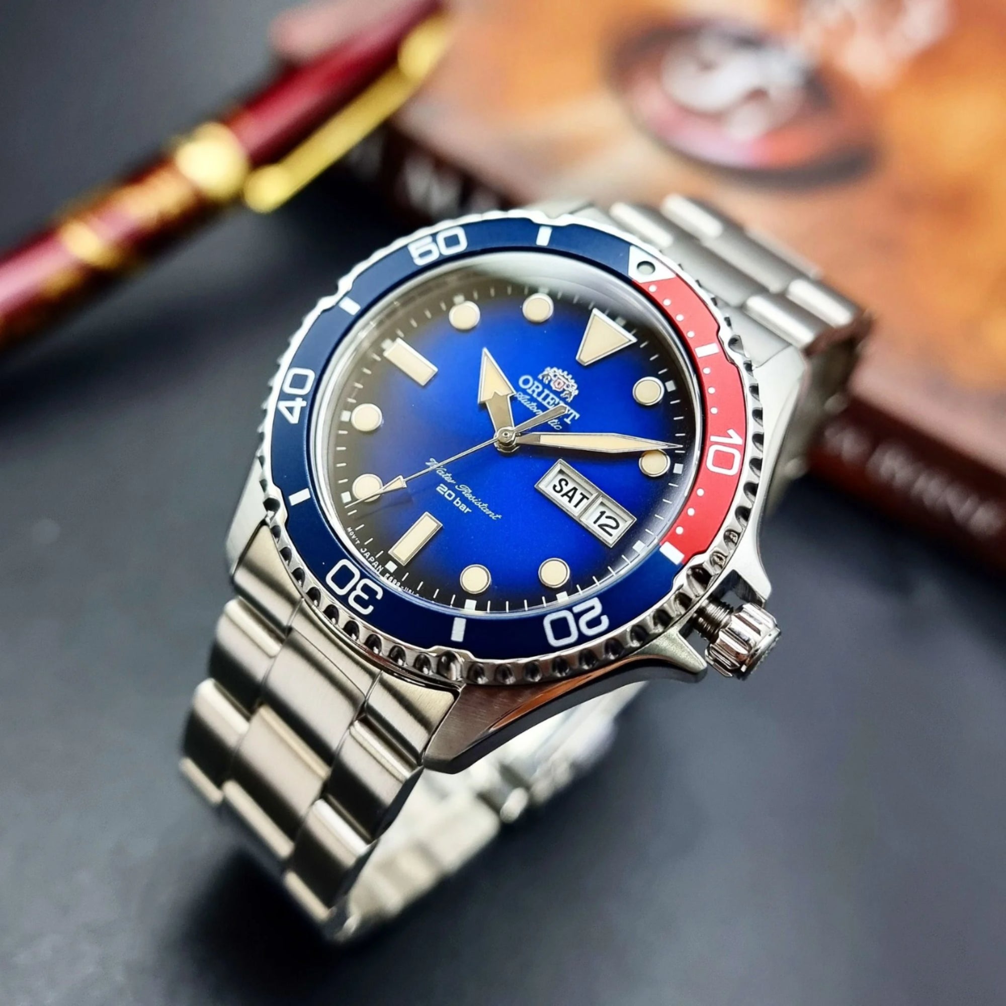 Wristwatch with blue and red bezel on a dark surface