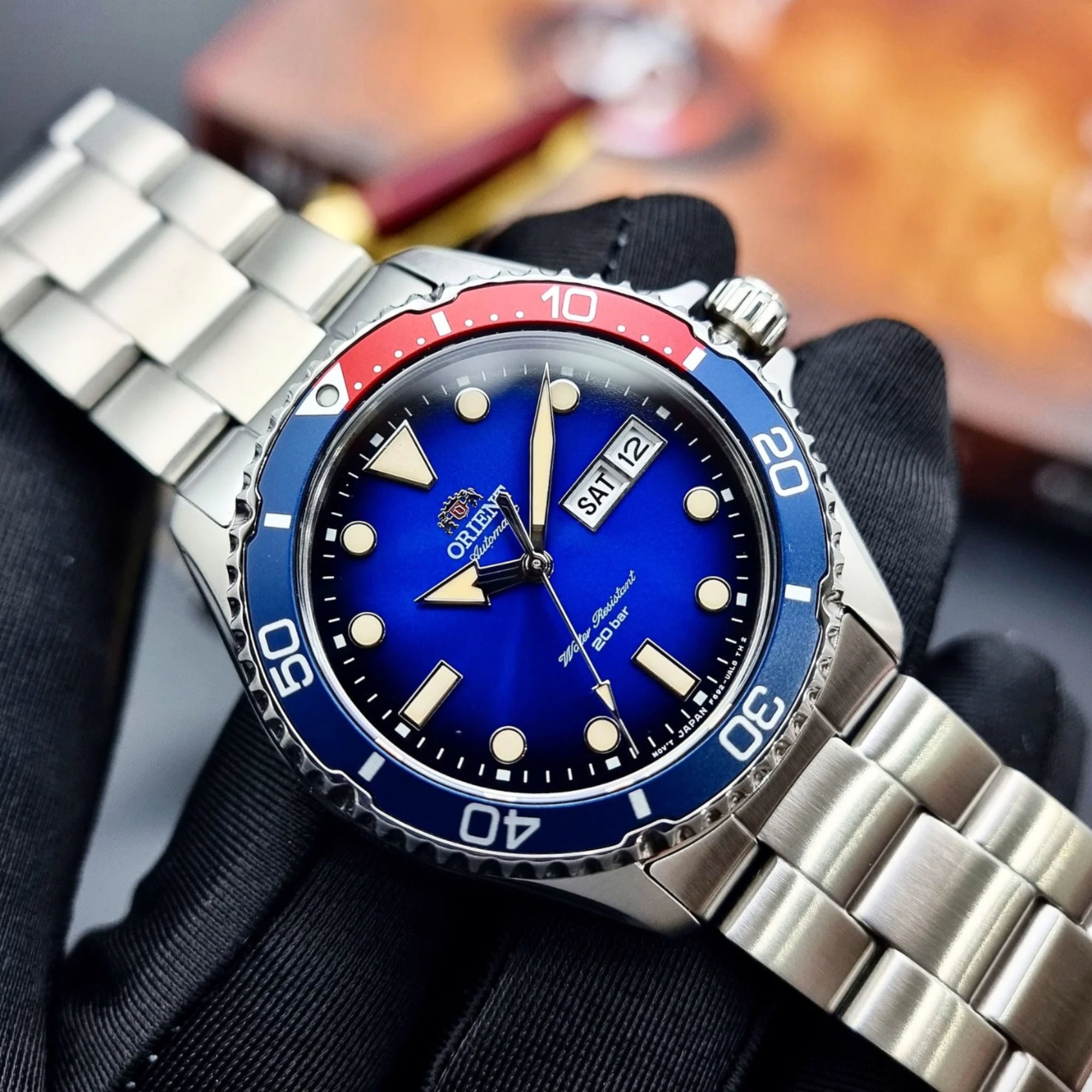 Watch with blue face and red and blue bezel on a metallic band