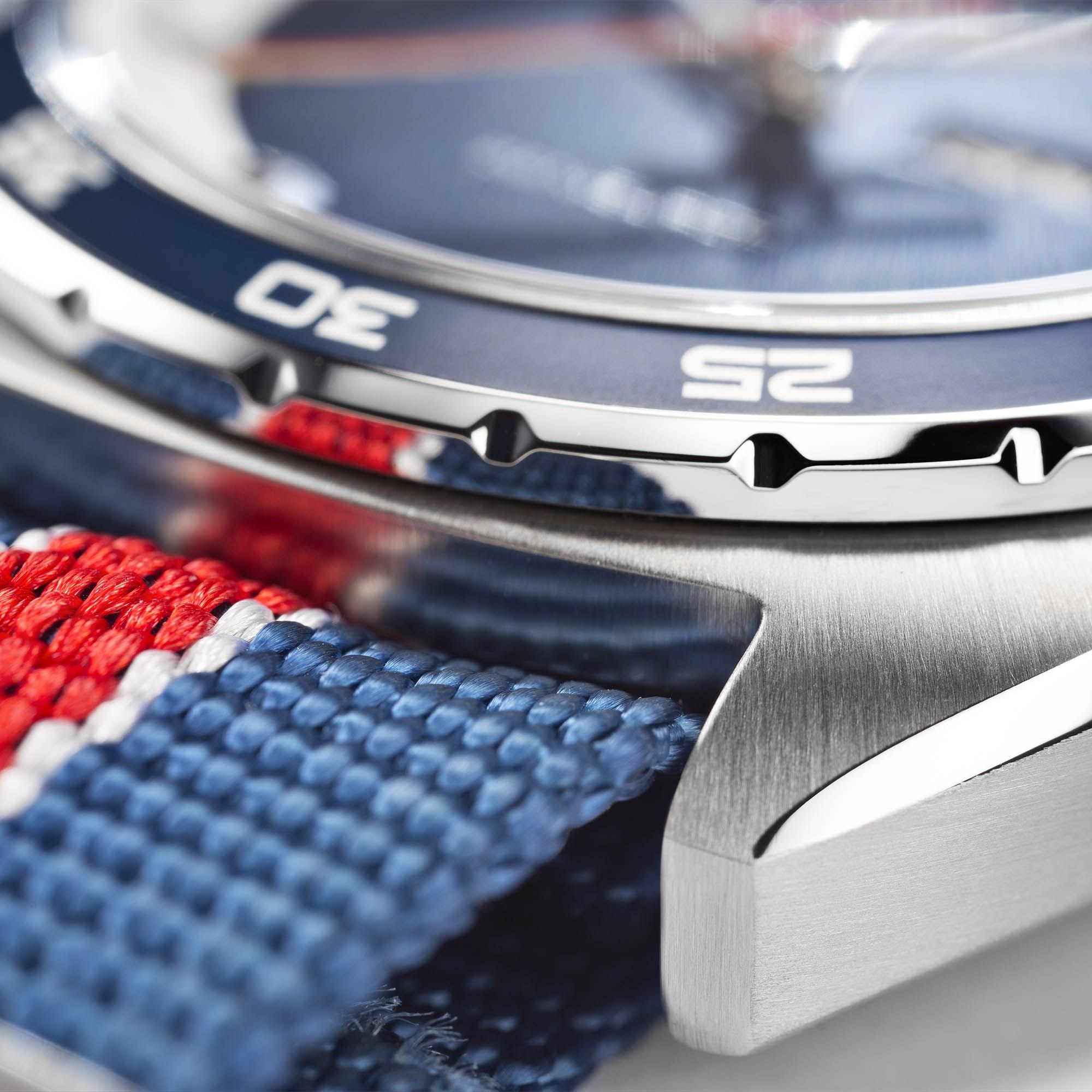 Close-up of a Hamilton watch featuring a blue dive bezel and a red, white, and blue striped textile NATO strap