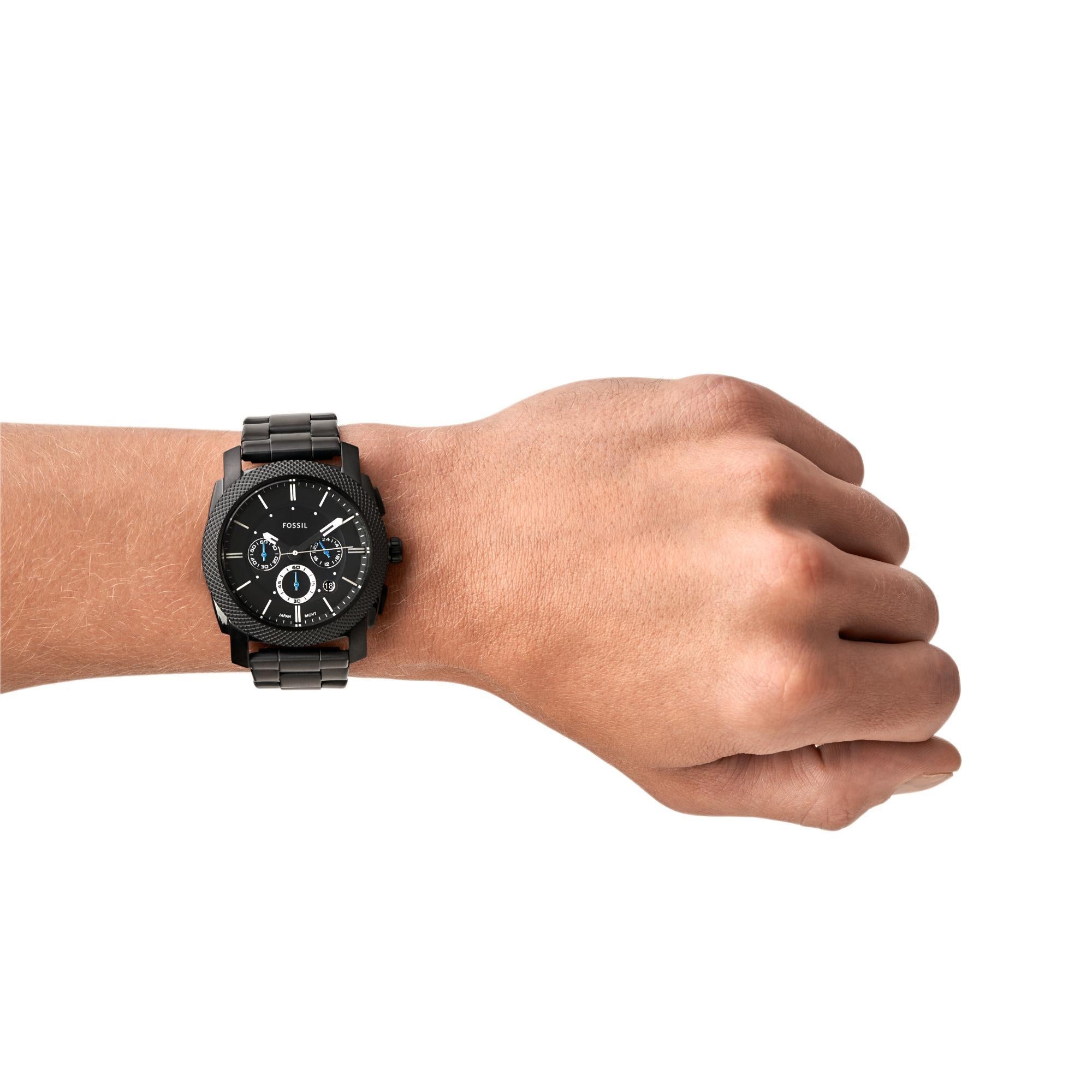 Black wristwatch on a person's wrist against a white background