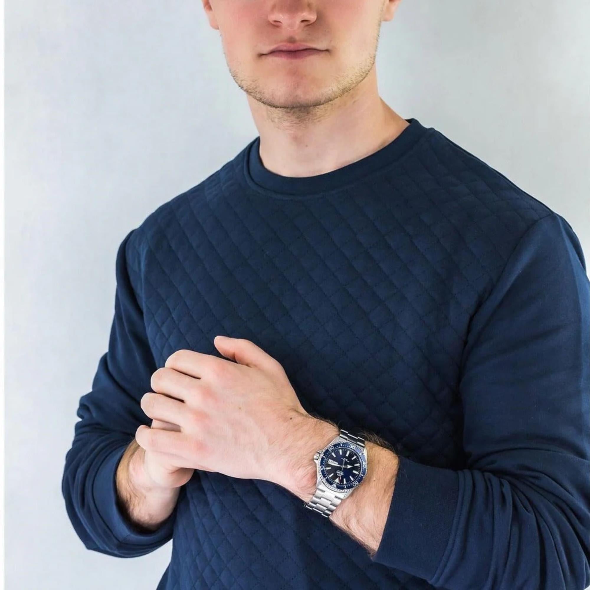 A man wearing a blue Orient Mako automatic watch on his wrist.