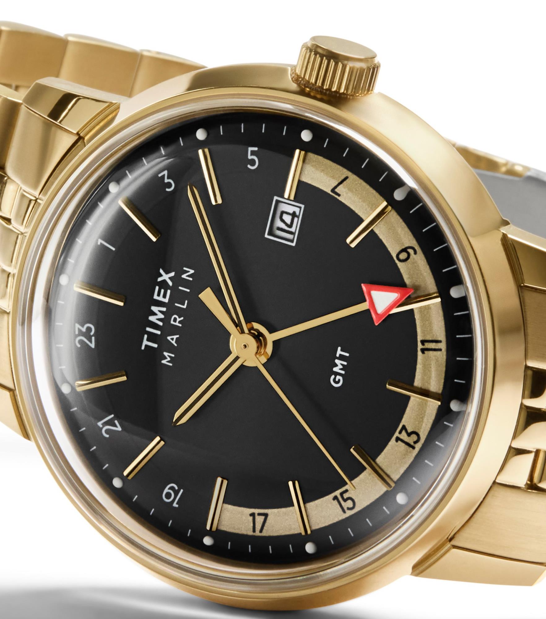 Timex TW2Y47700 domed crystal, black dial, gold-tone indices, and red-tipped GMT hand close-up angle view