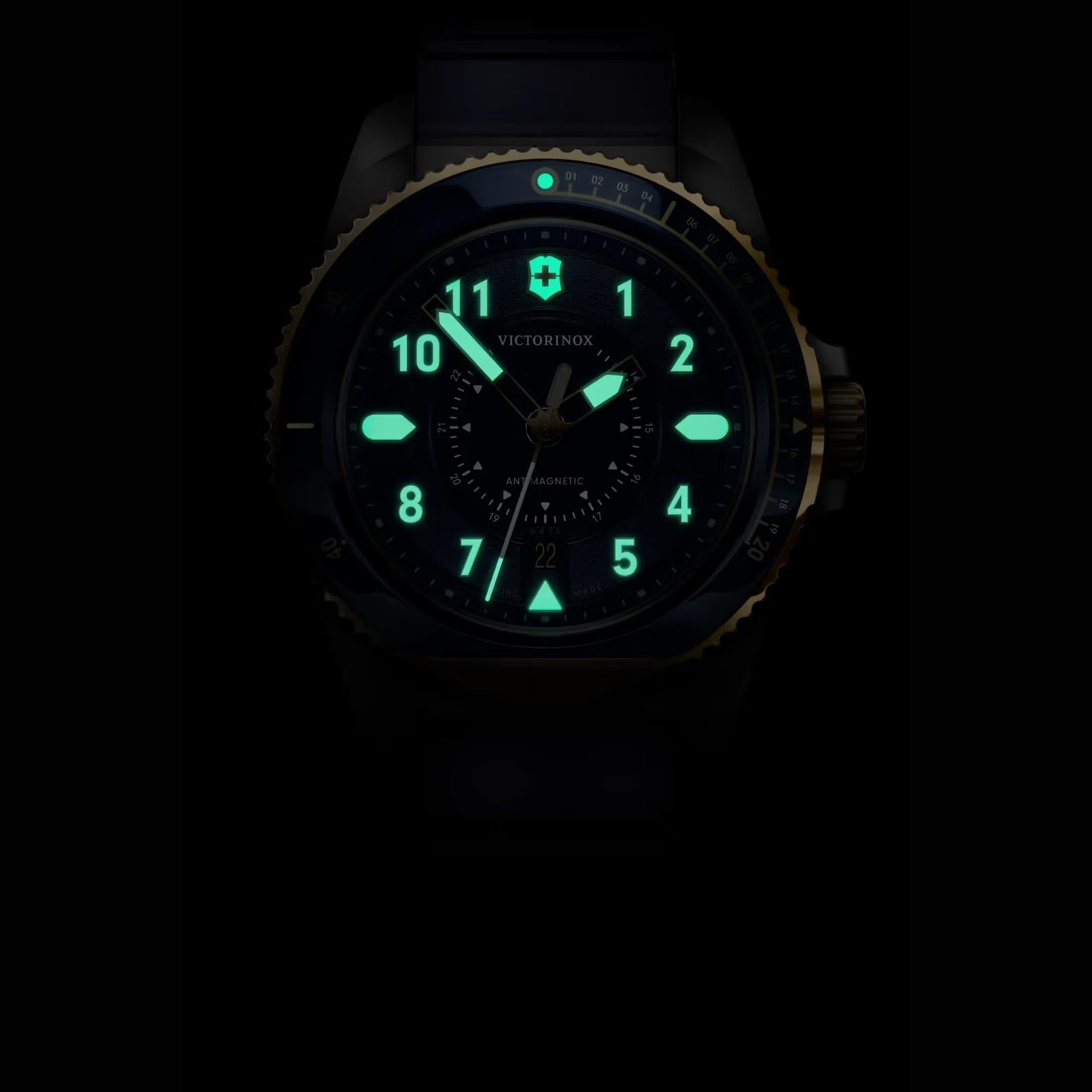 A Victorinox watch face glowing in the dark, featuring vibrant green luminous Arabic numerals hands