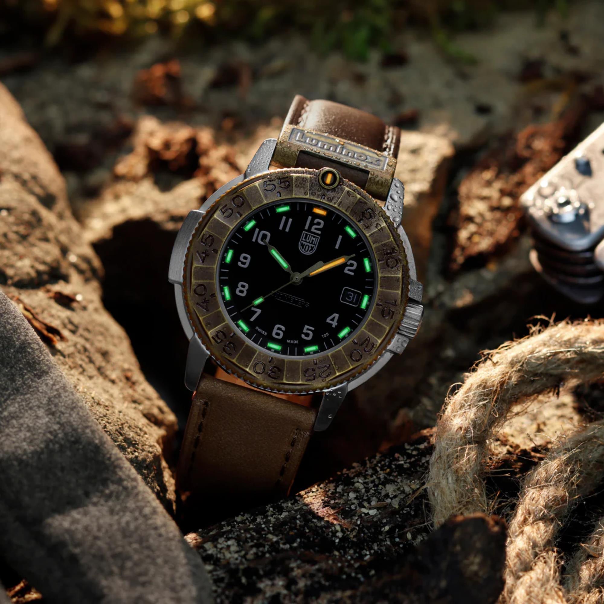 Close-up of the Luminox Adventure Watch XL.1301.LG wedged between a mossy rock and a thick coiled rope, showing water droplets on the case and its luminescent hour markers glowing in soft natural light