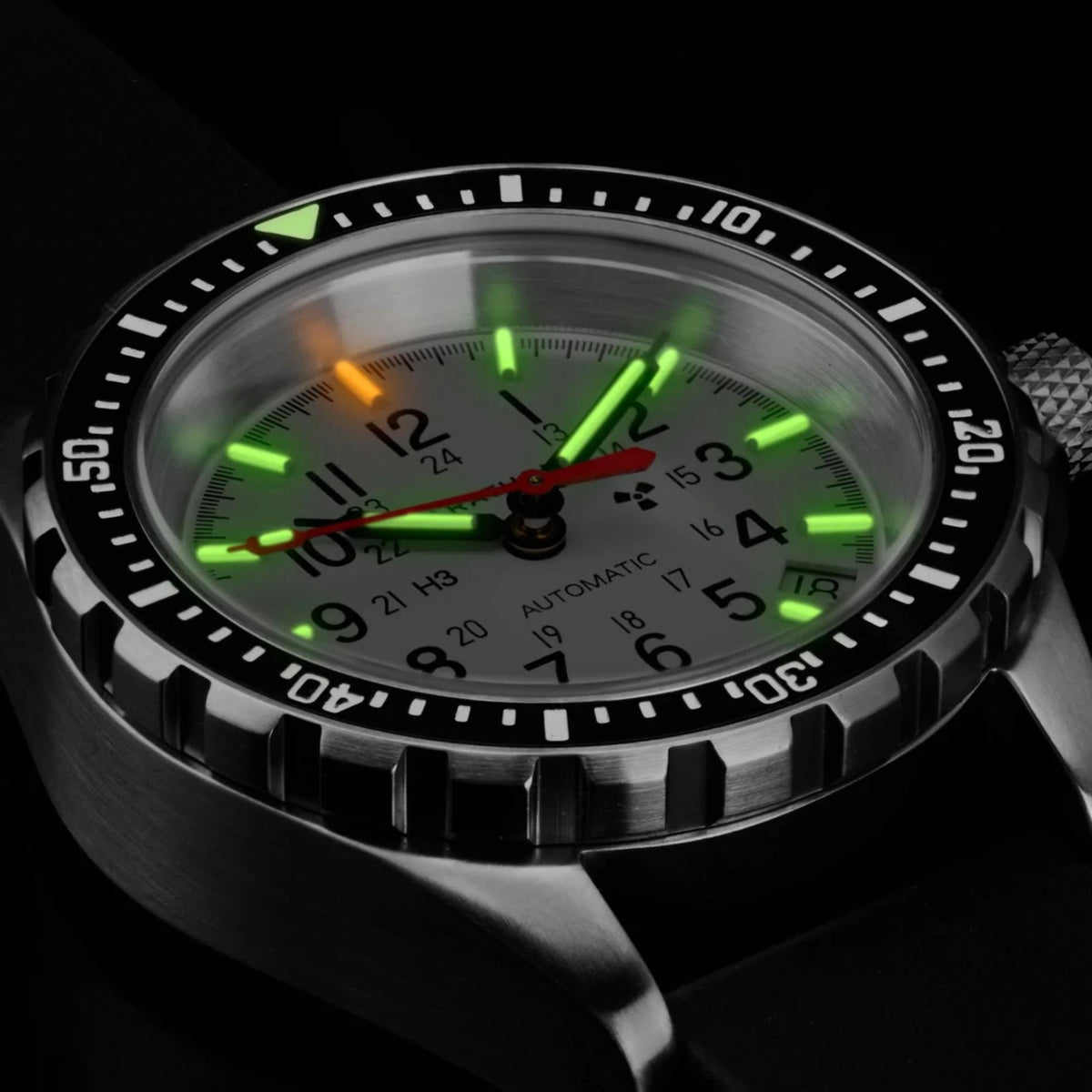 Marathon MSAR Arctic Edition WW194026SS-0506 automatic watch displaying glowing tritium gas tube indices on white dial in dark conditions