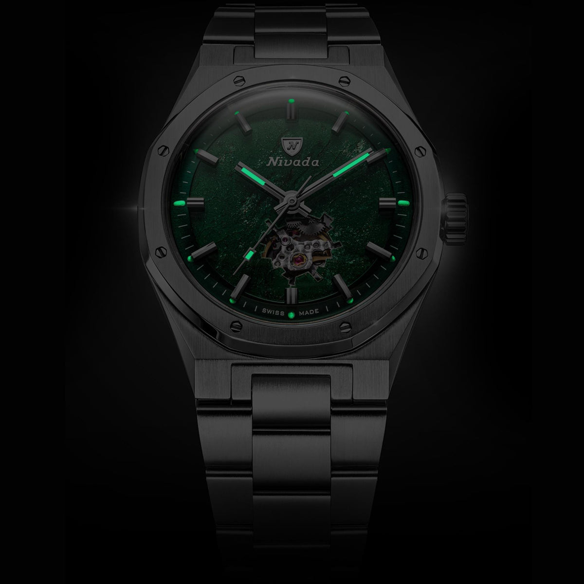Nivada Grenchen F77 MK2 68051A77 luminous hands and hour markers glowing green against dark aventurine dial in dim lighting