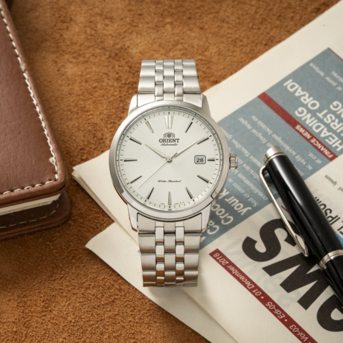 Orient Contemporary automatic watch with a white dial resting on a newspaper