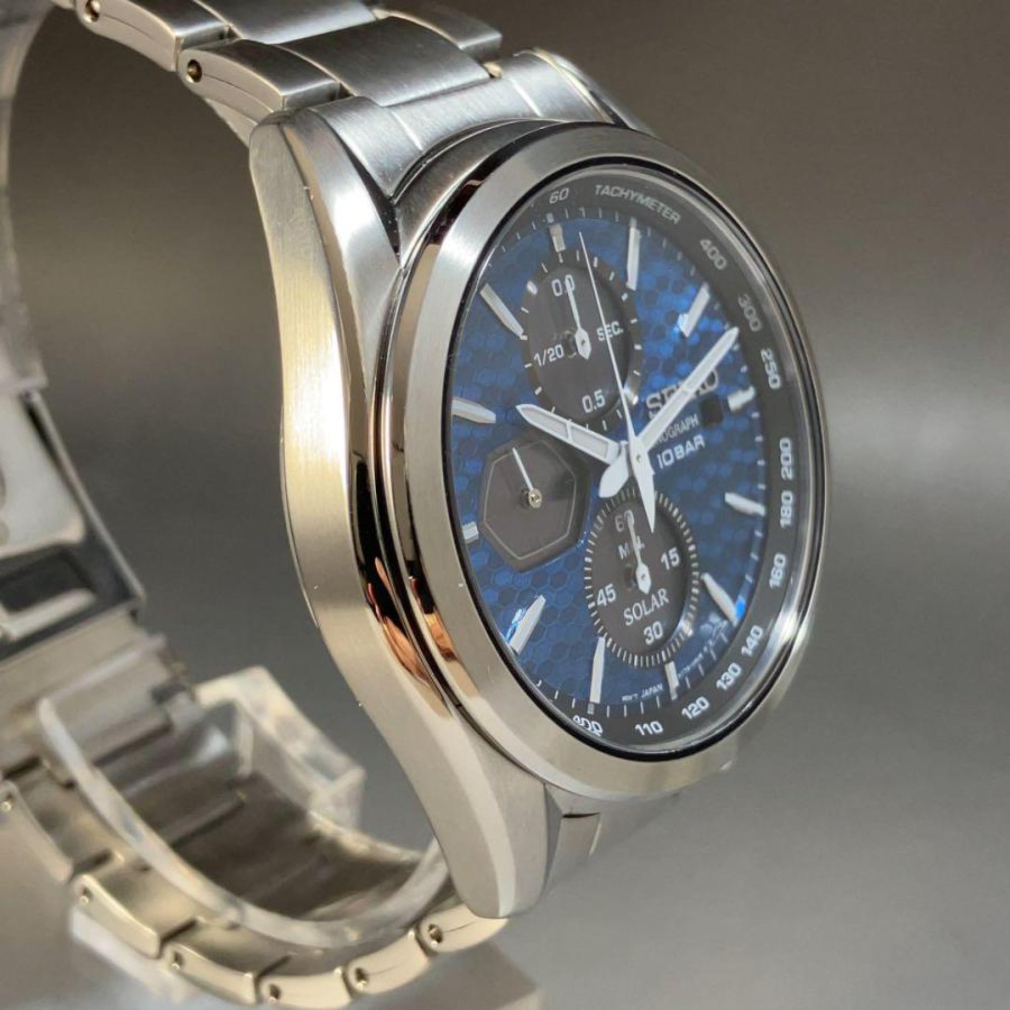 Side profile of a Seiko Essentials Solar Chronograph watch SSC801P1 highlighting its stainless steel case, bezel and blue dial
