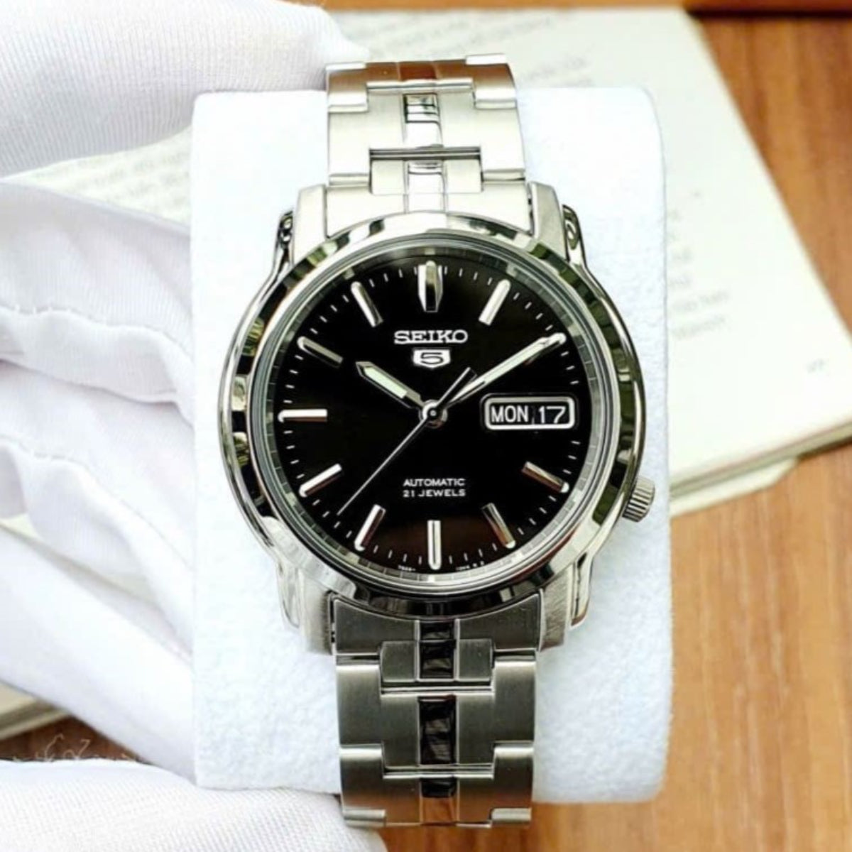 Seiko 5 Automatik Herrenarmbanduhr mit schwarzem Zifferblatt und Stahlarmband SNKK71K1