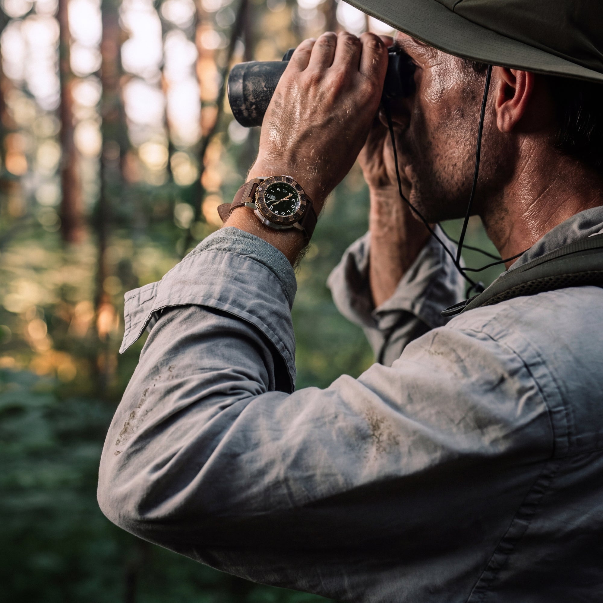 Side view of an explorer in a forest, wearing a green outdoor hat and the Luminox Adventure Watch XL.1301.LG on a brown leather strap