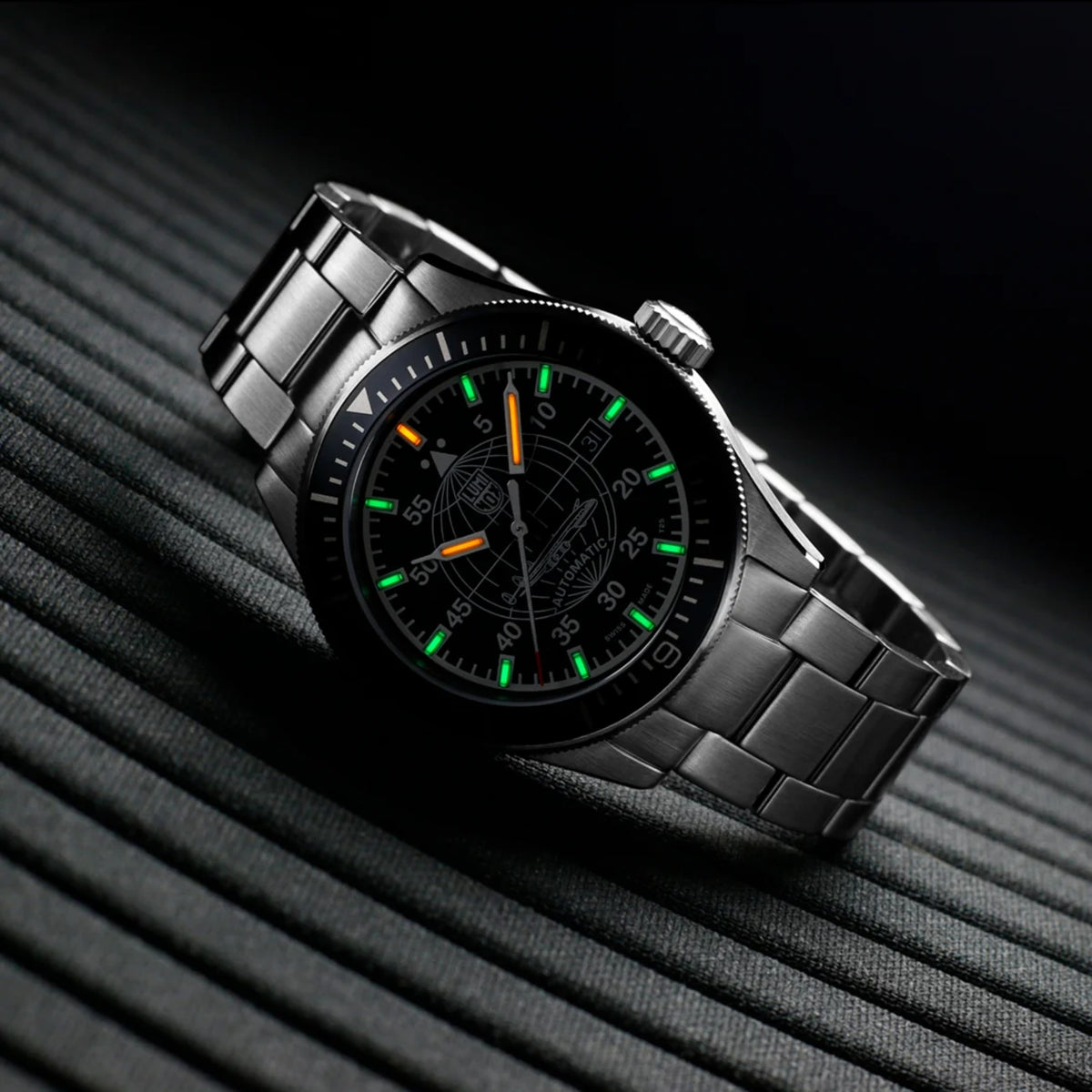 Luminox Constellation 9600 Series XA.9601.M angled low light view displaying illuminated gas tubes against black dial and steel bracelet