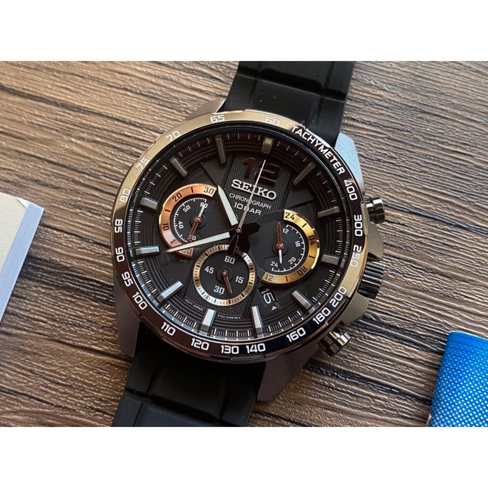 Seiko watch with black and gold details on a wooden surface