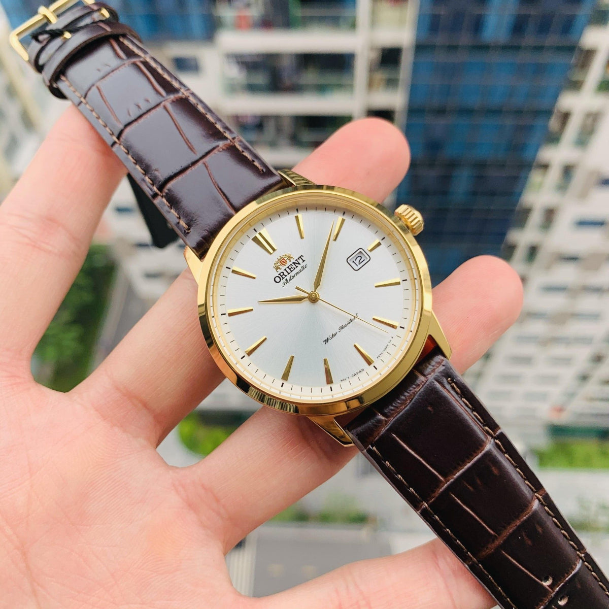 Orient Symphony automatic watch with a  white dial and brown leather strap.