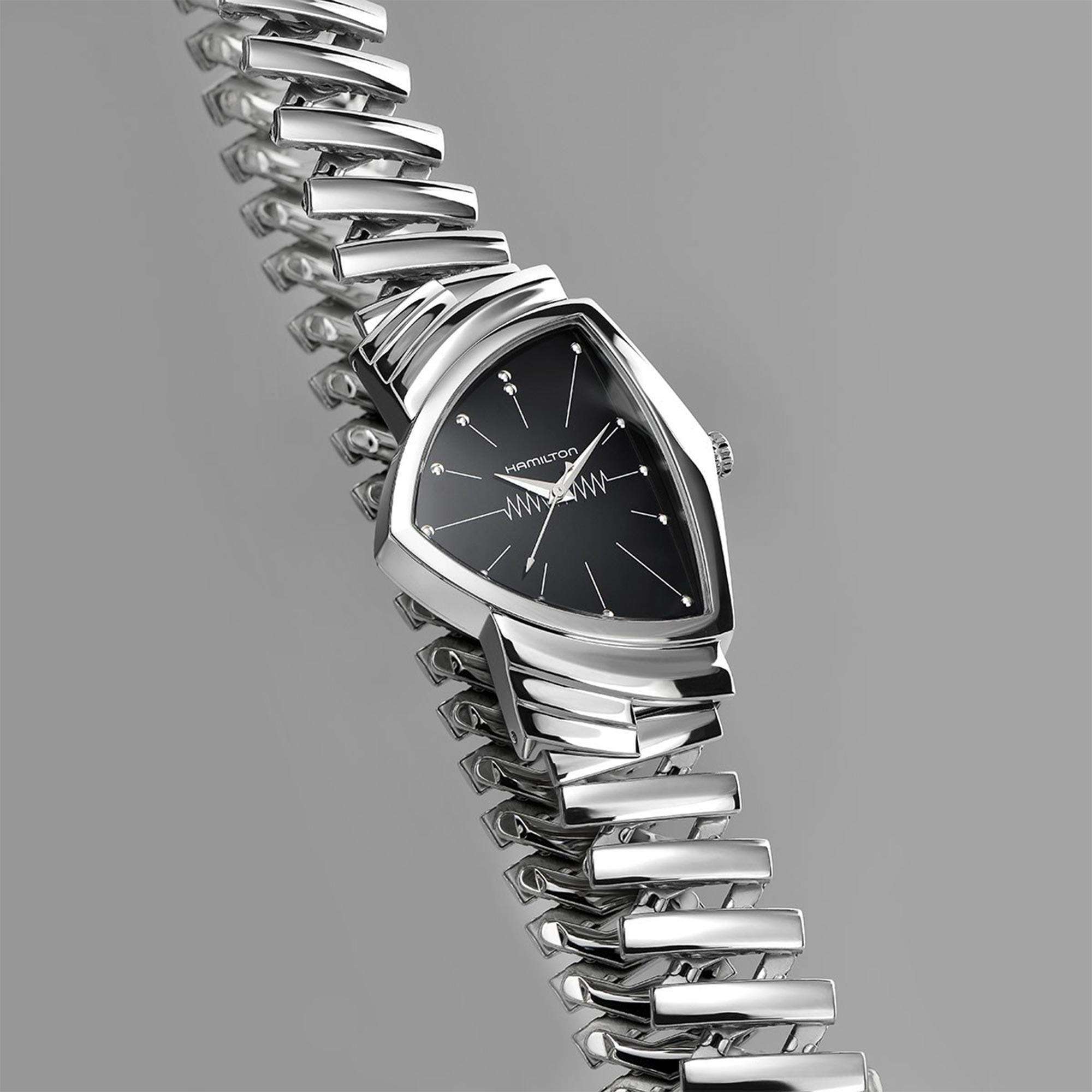 Angled overhead view of a Hamilton Ventura watch with a triangular case and an expanded stainless steel flex bracelet