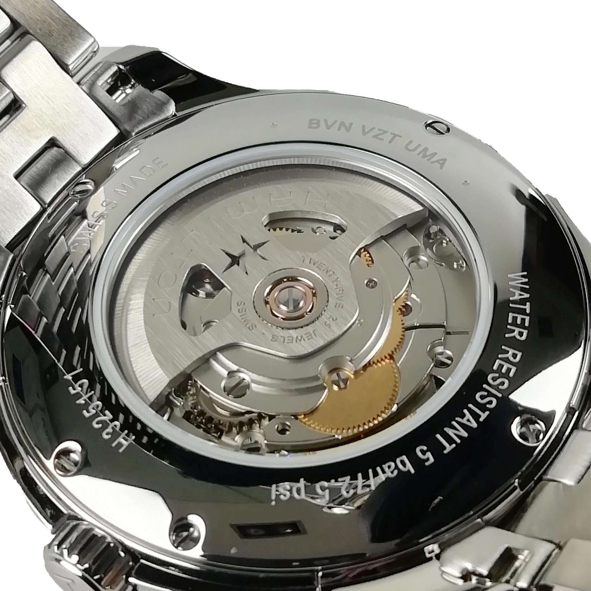 Close-up of a watch mechanism with visible branding on a white background