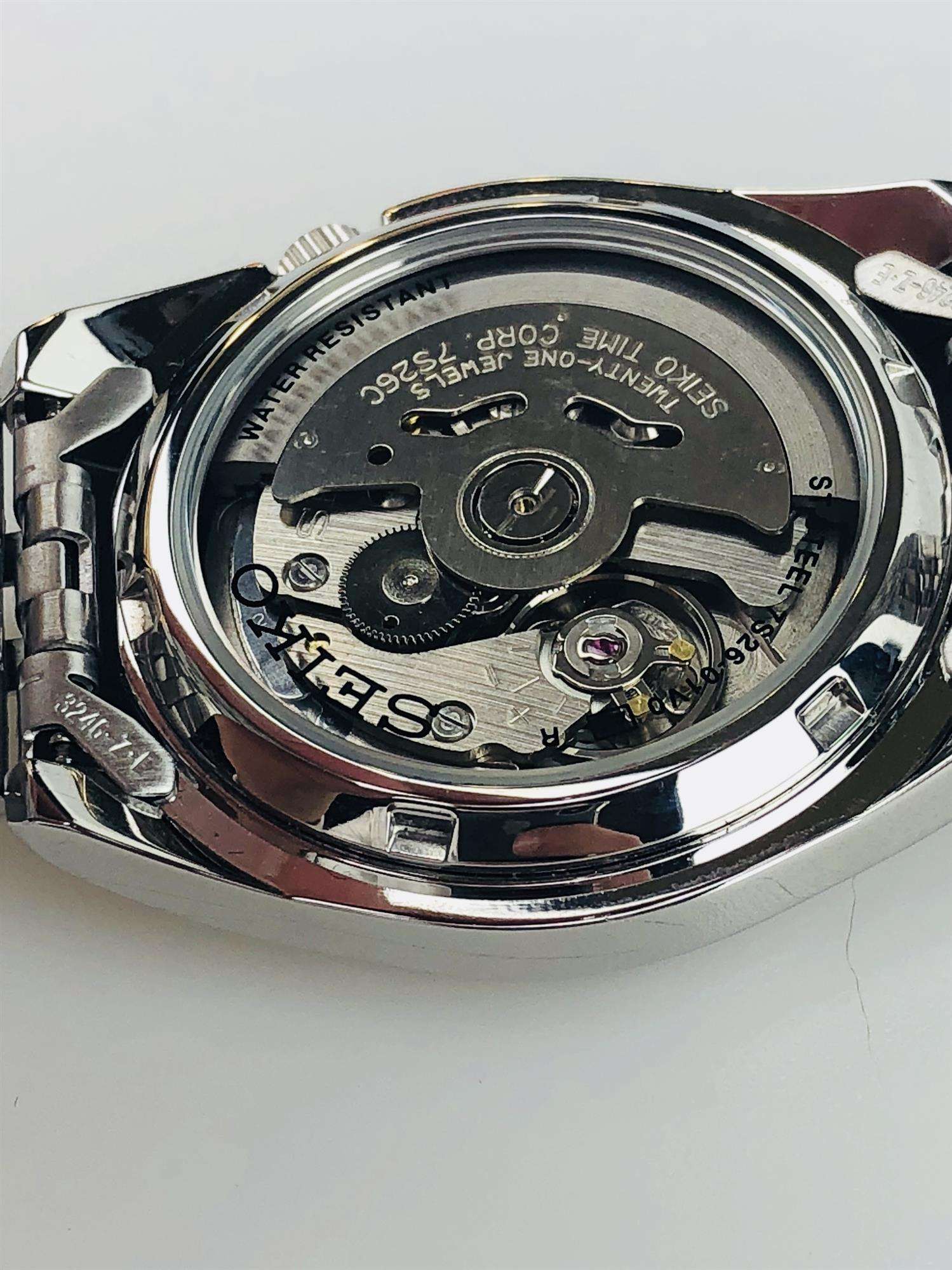 Seiko SNK355K1 exhibition case-back showing automatic movement with 21 jewels and stainless steel bracelet