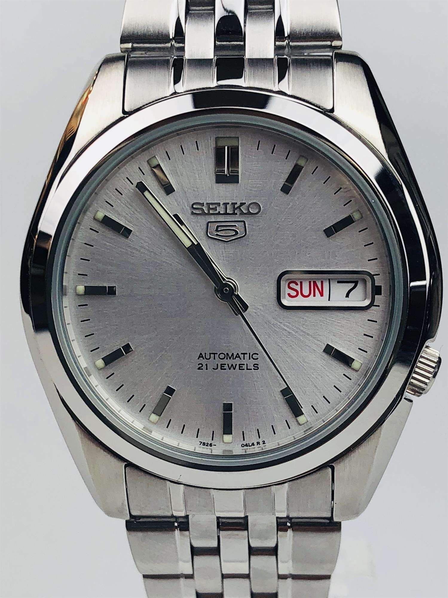 Seiko 5 Automatic SNK355K1 silver dial stainless steel men's watch close-up angled view with date window "SUN 7"