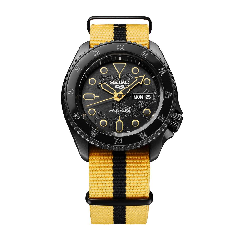Seiko watch with black dial and yellow strap on a white background