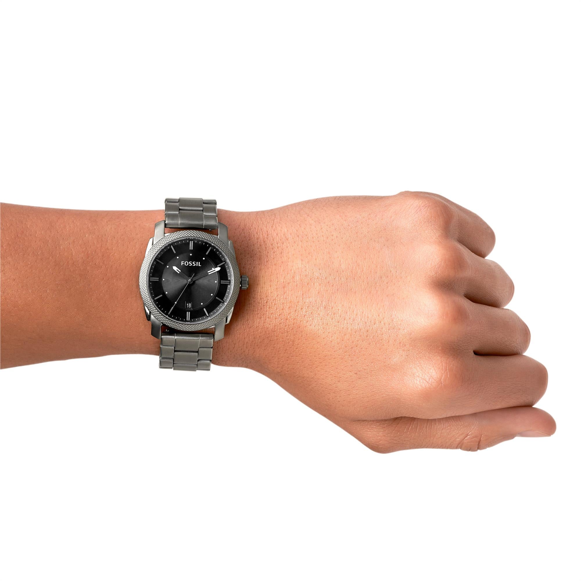 Person wearing a Fossil watch on a white background