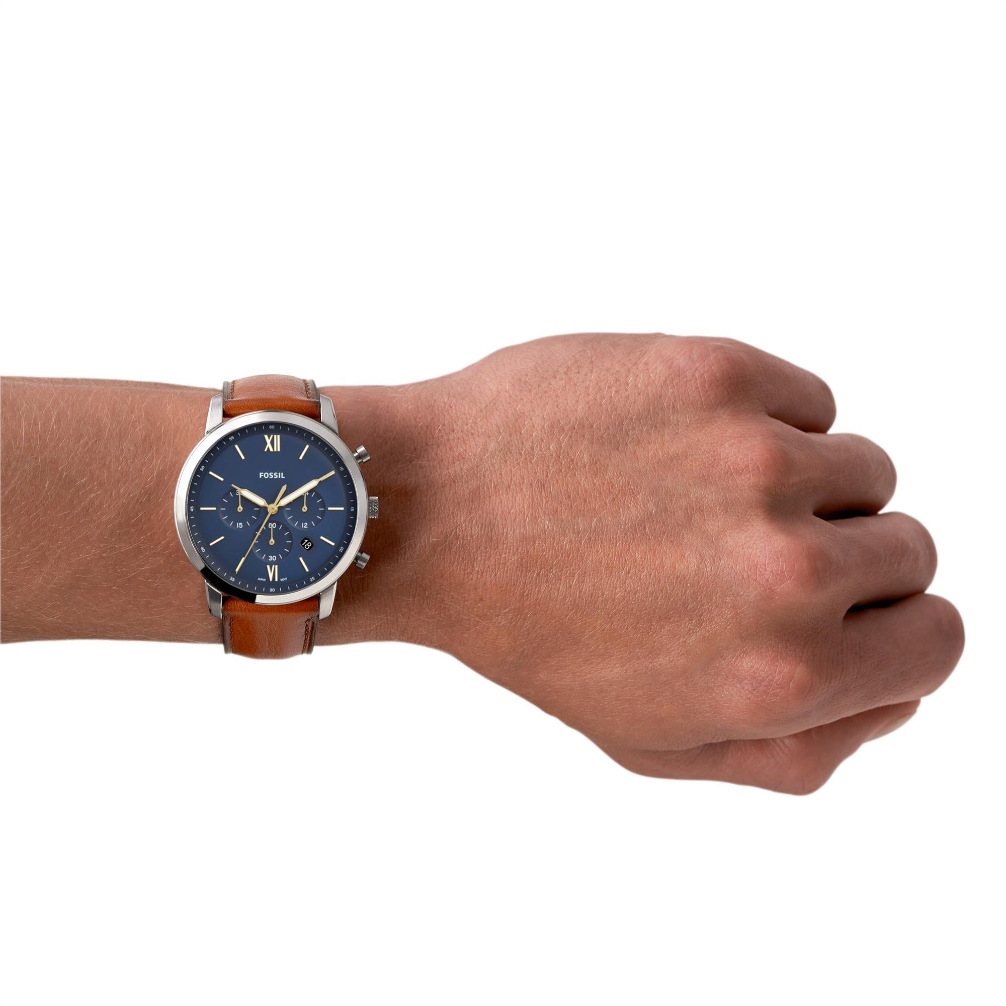 Hand wearing a watch with a brown leather strap and blue face on a white background