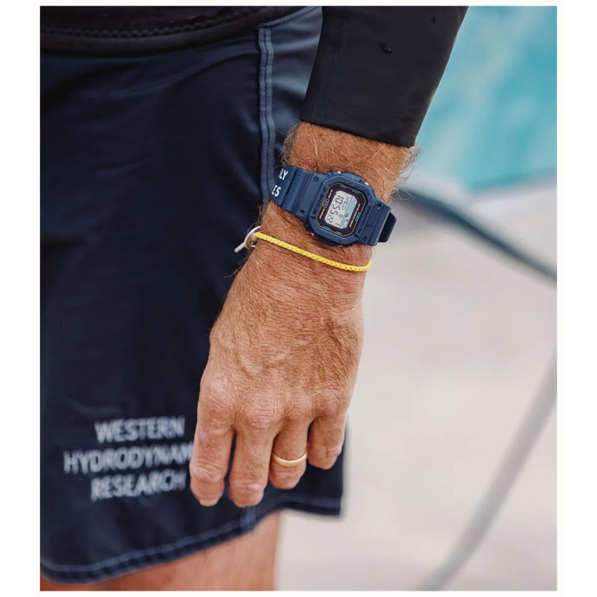 Person wearing a blue digital watch on a blurred background