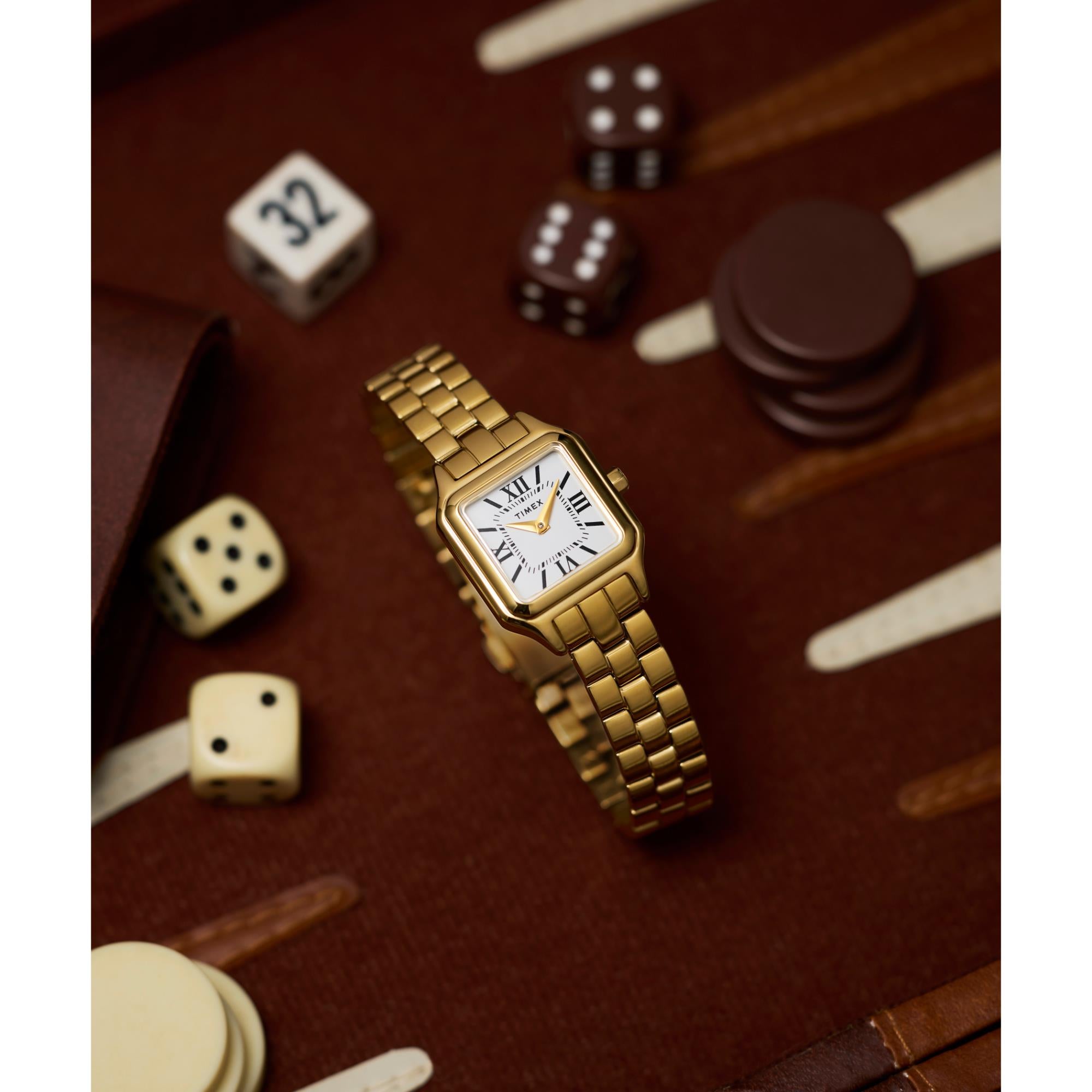Timex TW2Y23700 gold-tone steel watch displayed next to gaming dice view