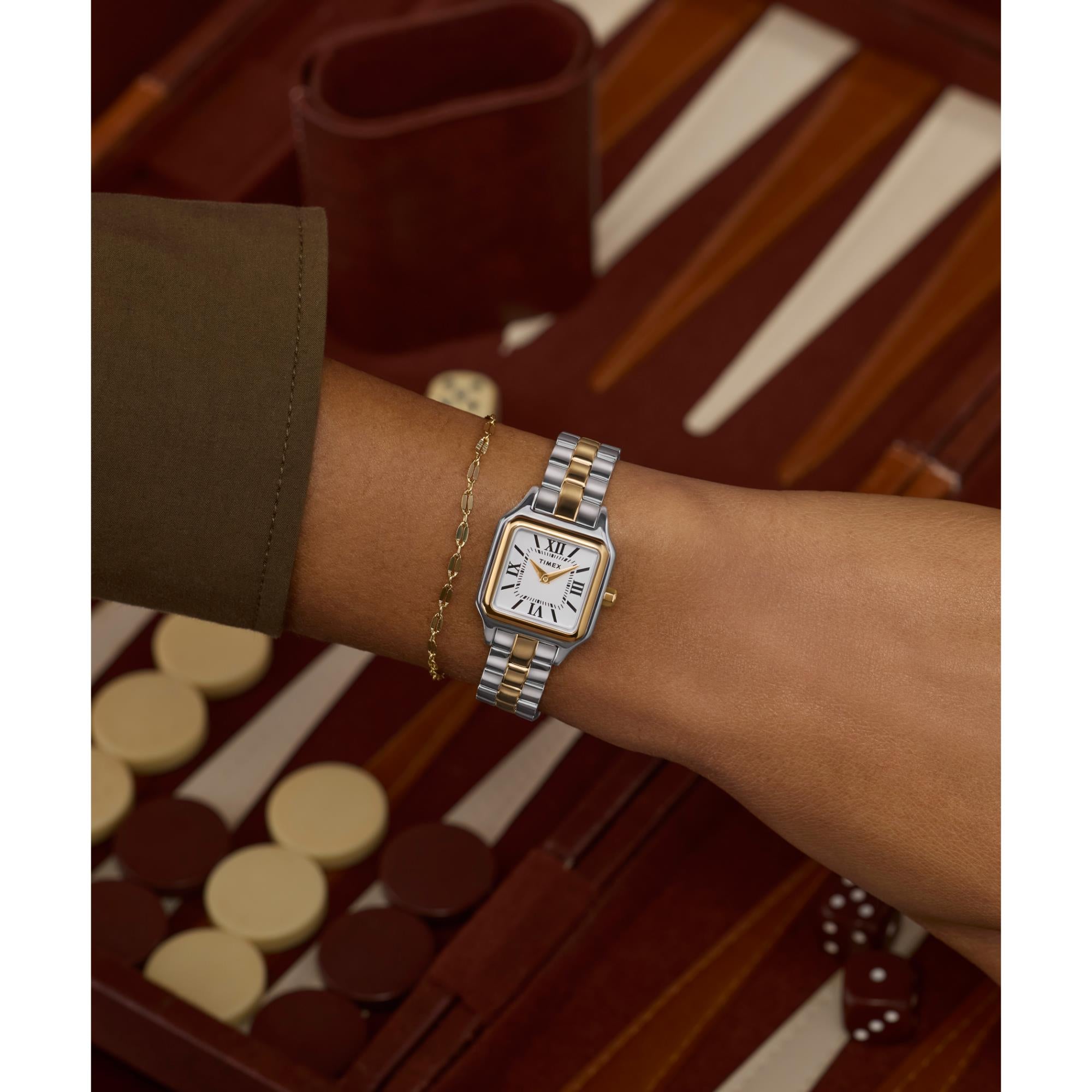 Timex TW2Y23900 two-tone watch paired with a gold chain bracelet on a wrist.