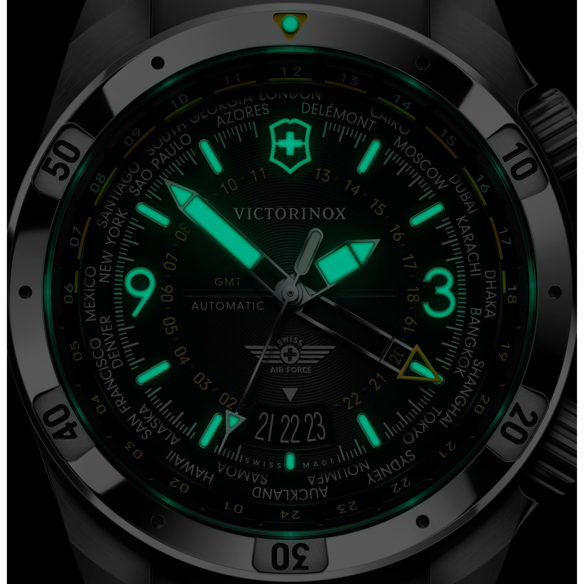 Victorinox Air Pro 242004 GMT automatic watch with intense green lume on black dial in dark environment