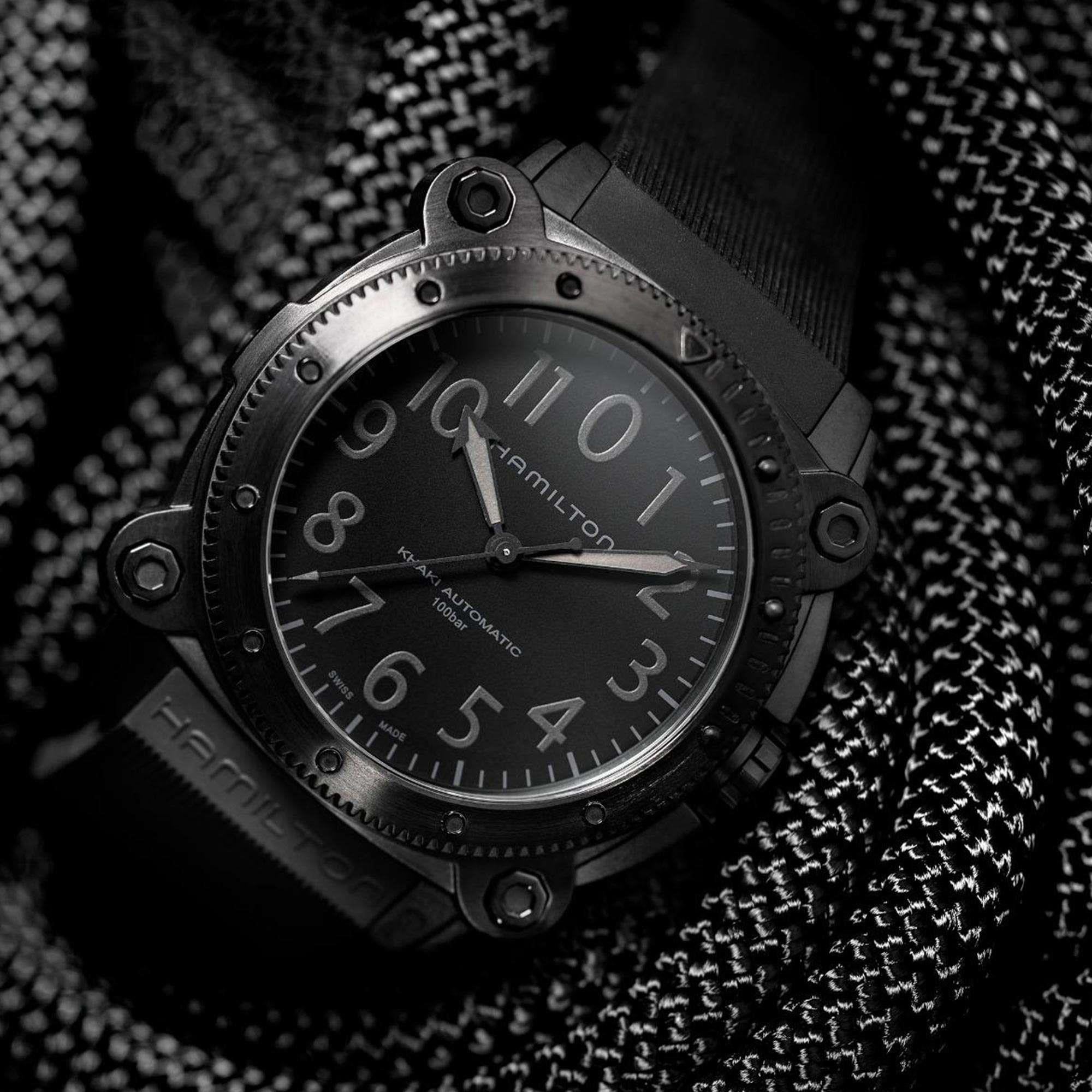 Hamilton Khaki Navy black automatic diver watch with 1000m water resistance shown in dramatic lighting