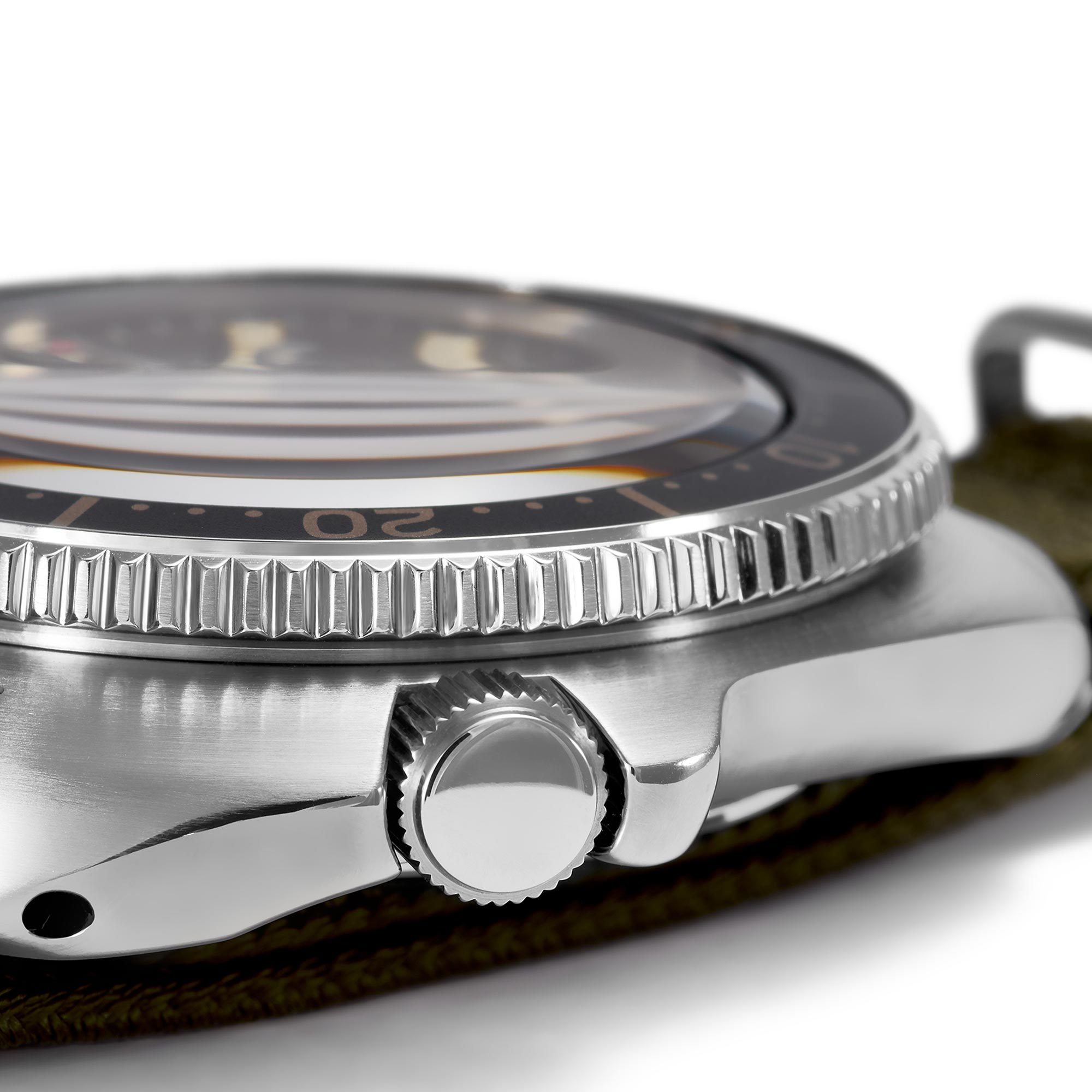 Close-up of a silver watch with a detailed bezel and leather strap.