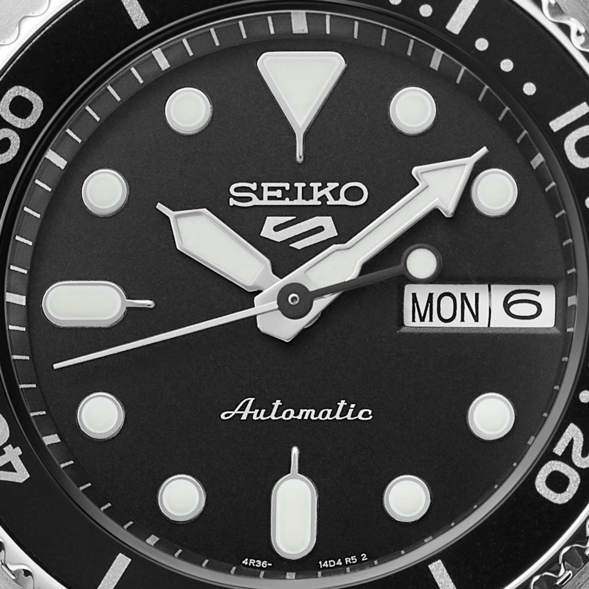 Seiko watch face with black background and white markings