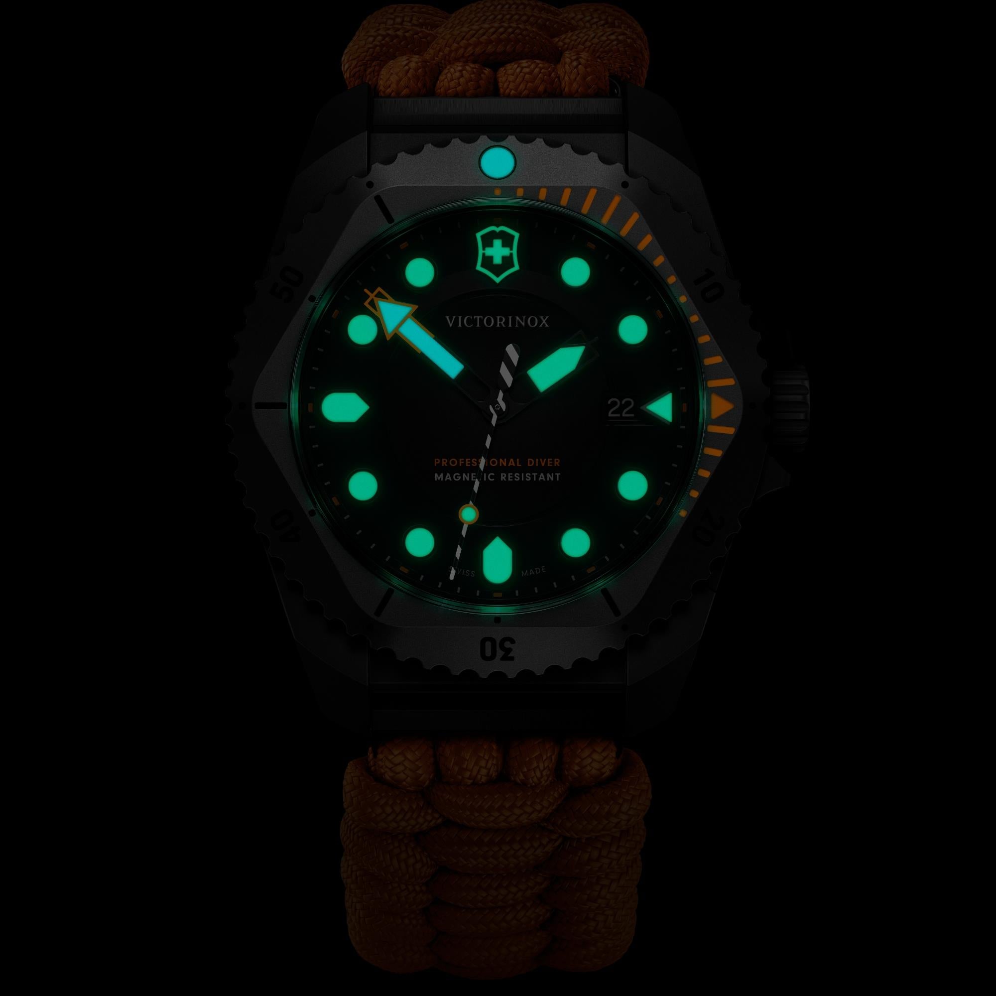 A dark close-up of a Victorinox Dive Pro watch featuring green and blue glowing lume