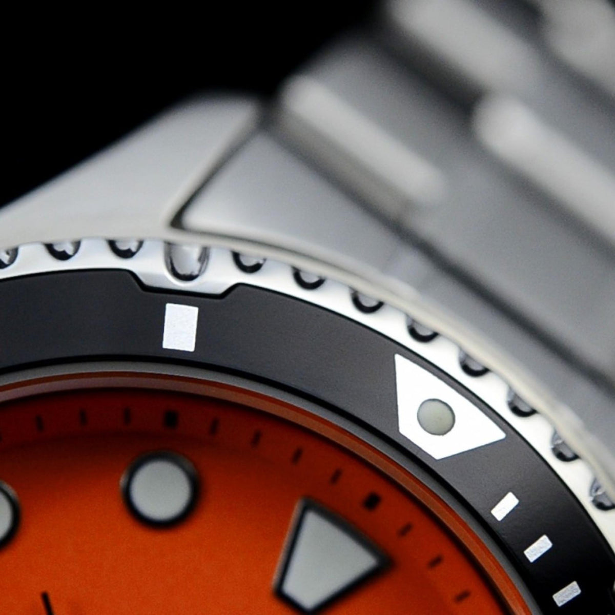Orient Ray TAA02006M9 detailed view of black rotating bezel edge, steel lug, and top ring