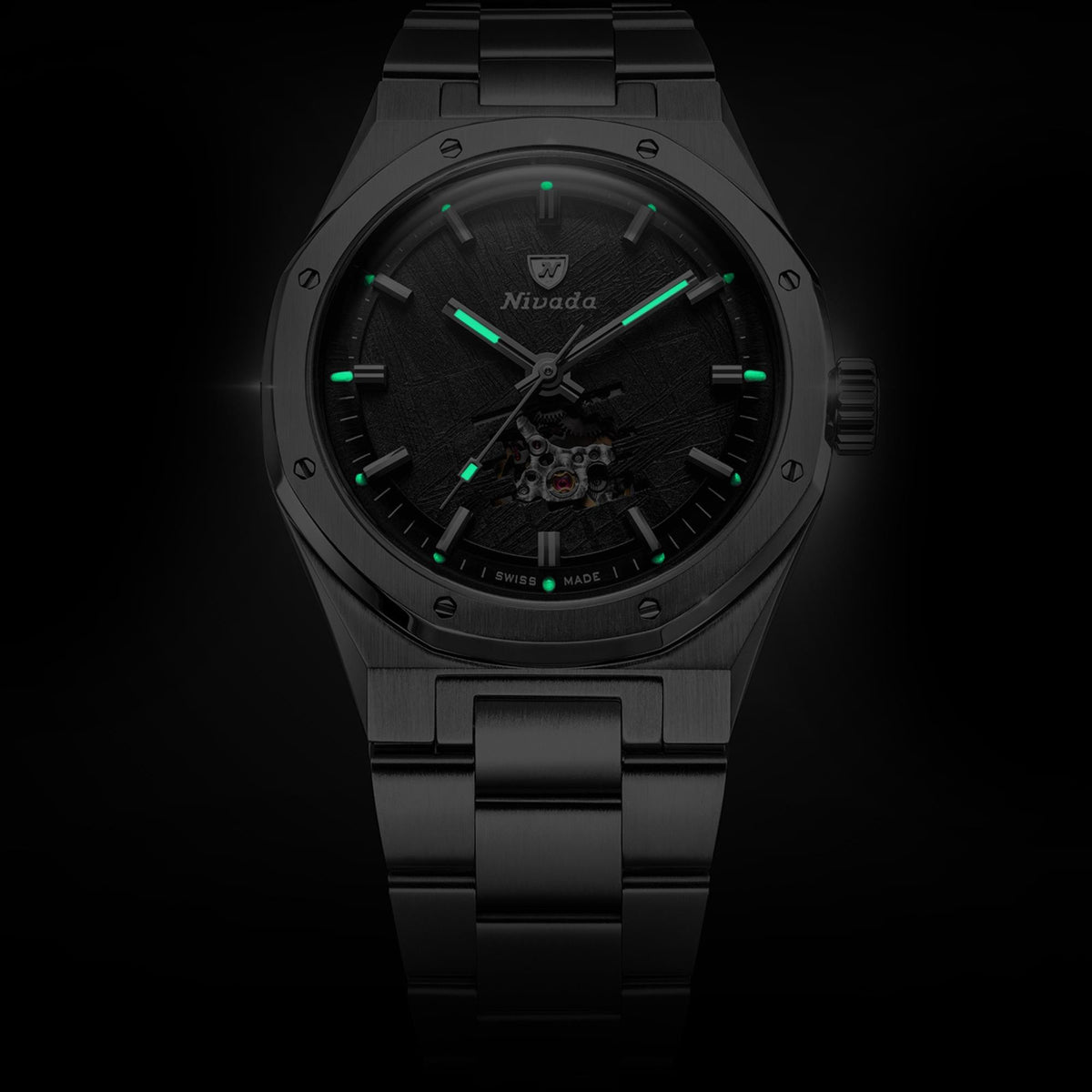 Nivada Grenchen F77 MK2 68052A77 luminous hands and hour markers glowing green against dark meteorite dial in dim lighting