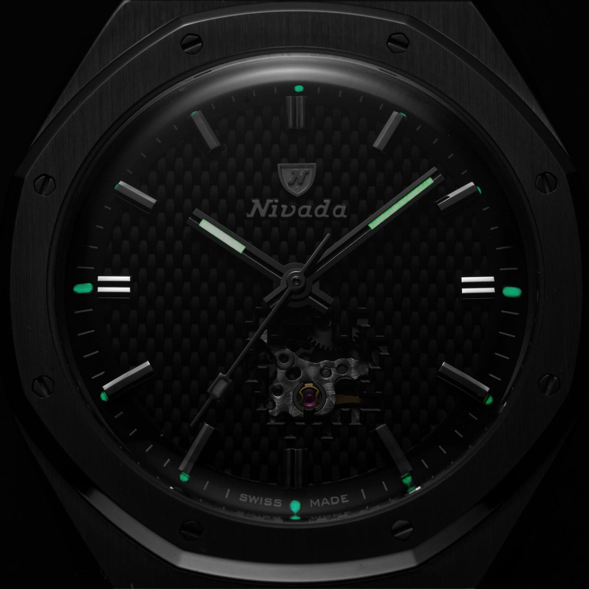 Nivada Grenchen F77 MK2 68023A77-BC macro shot of green luminous hands and hour markers glowing in dark environment over carbon face