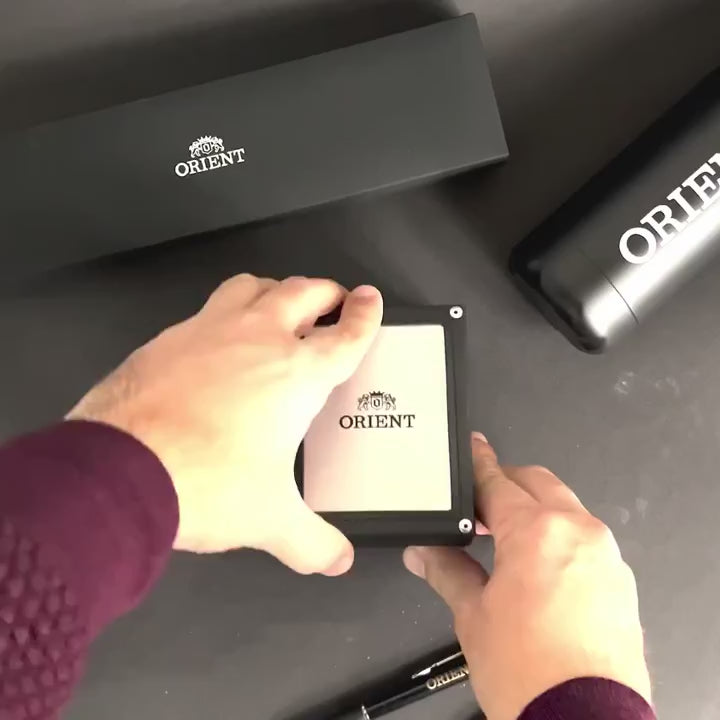 Orient World Map RA-AA0E03L39B top-down unboxing view showcasing branded watch box, manual, and accessories